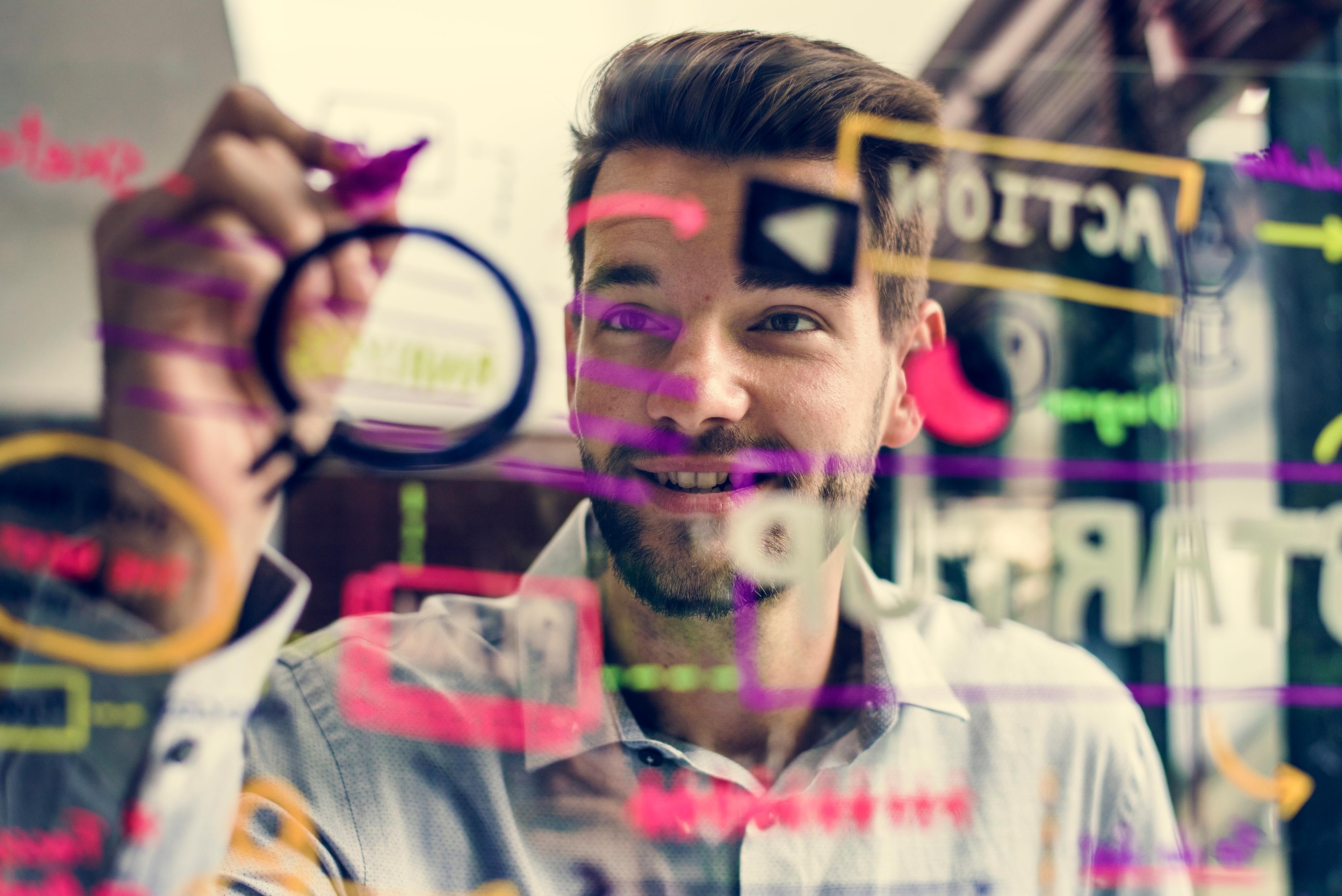 Jeune homme dessinant sur une vitre